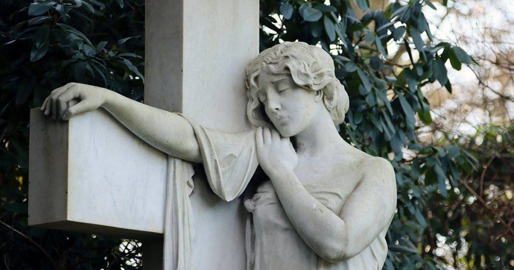 statue of a woman with a cross