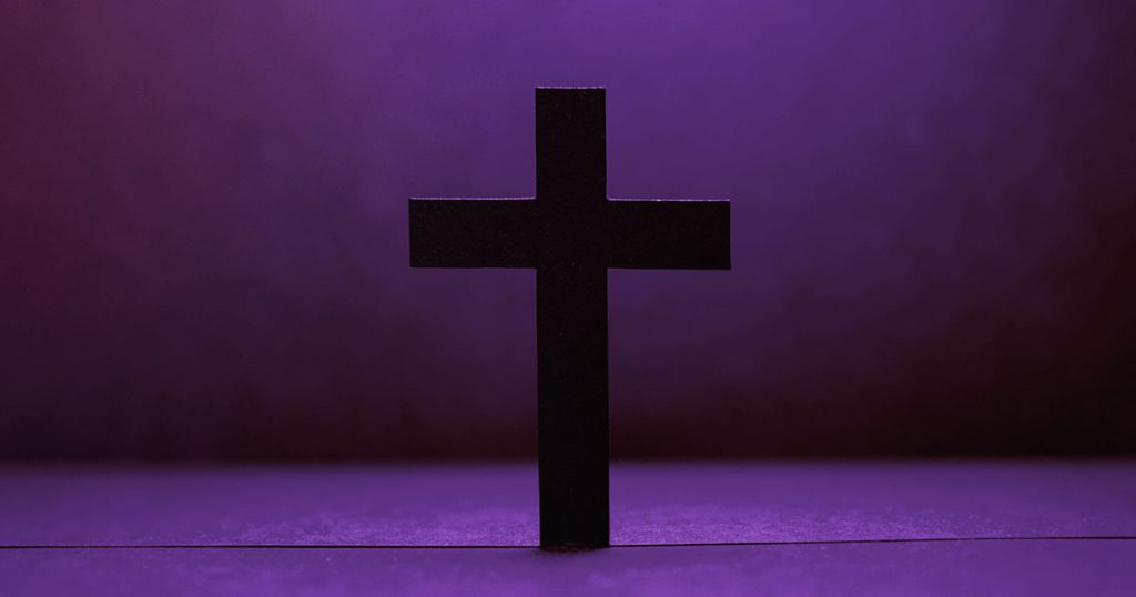 Cross in front of dark purple background