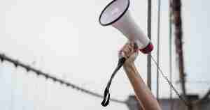 Close up of a hand holding a bullhorn.