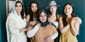 Group of women of different ethnicities and religions posing together.